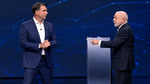 Flávio Bolsonaro e Lula durante debate na Band, em imagem com enquadramento ajustado e qualidade visual aprimorada.