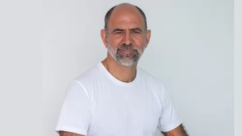 Celso Tádhei sentado, escritor e roteirista finalista do Prêmio Jabuti 2025